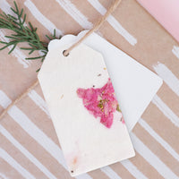 A close-up of a wrapped gift tied with twine, featuring a Pink Blank Tags Plantable Seed Paper by Seed Bloom Gifts