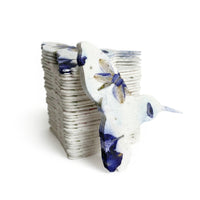 A collection of blue and white ceramic birds, including a hummingbird, designed for memorial plantable seed paper