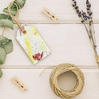 Single Pink and Yellow Plantable Seed Paper Blank Gift Tags by Seed Bloom Gifts styled with lavender and natural twine on a white wooden surface.