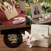A hand displays a butterfly card alongside plantable seed paper labeled Hummingbird Memorial