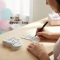 Person writing on A Baby footprint seed paper baby shower favor by Seed Bloom Gifts with 'Write a note, share the love' text in the background.