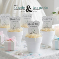 Staged photo of five white terracotta pots holding gender neutral green onesie plantable seed paper baby shower favors by Seed Bloom gifts and planting guides. The scene is decorated with pink and blue confetti and small gift boxes.