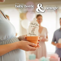 Baby bottle baby shower seed paper favor by Seed Bloom Gifts and terracotta pot set with 'baby bloom' design, held by a pregnant person