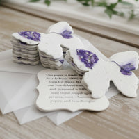 White paper butterflies with purple accents on a wooden surface