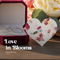 Plantable seed paper wedding favor cut in a heart shape, featuring large embedded pink and yellow dried flower petals and visible texture by Seed Bloom Gifts