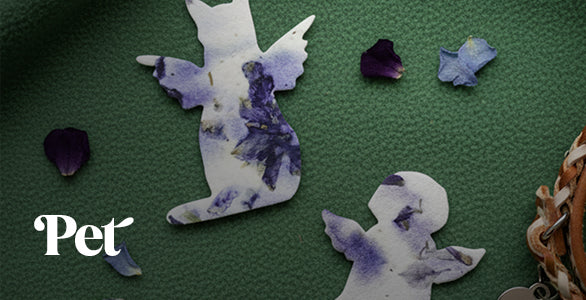 Decorative angel-shaped seed paper by Seed Bloom Gifts with floral patterns on a green surface, featuring the brand 'Pet'.