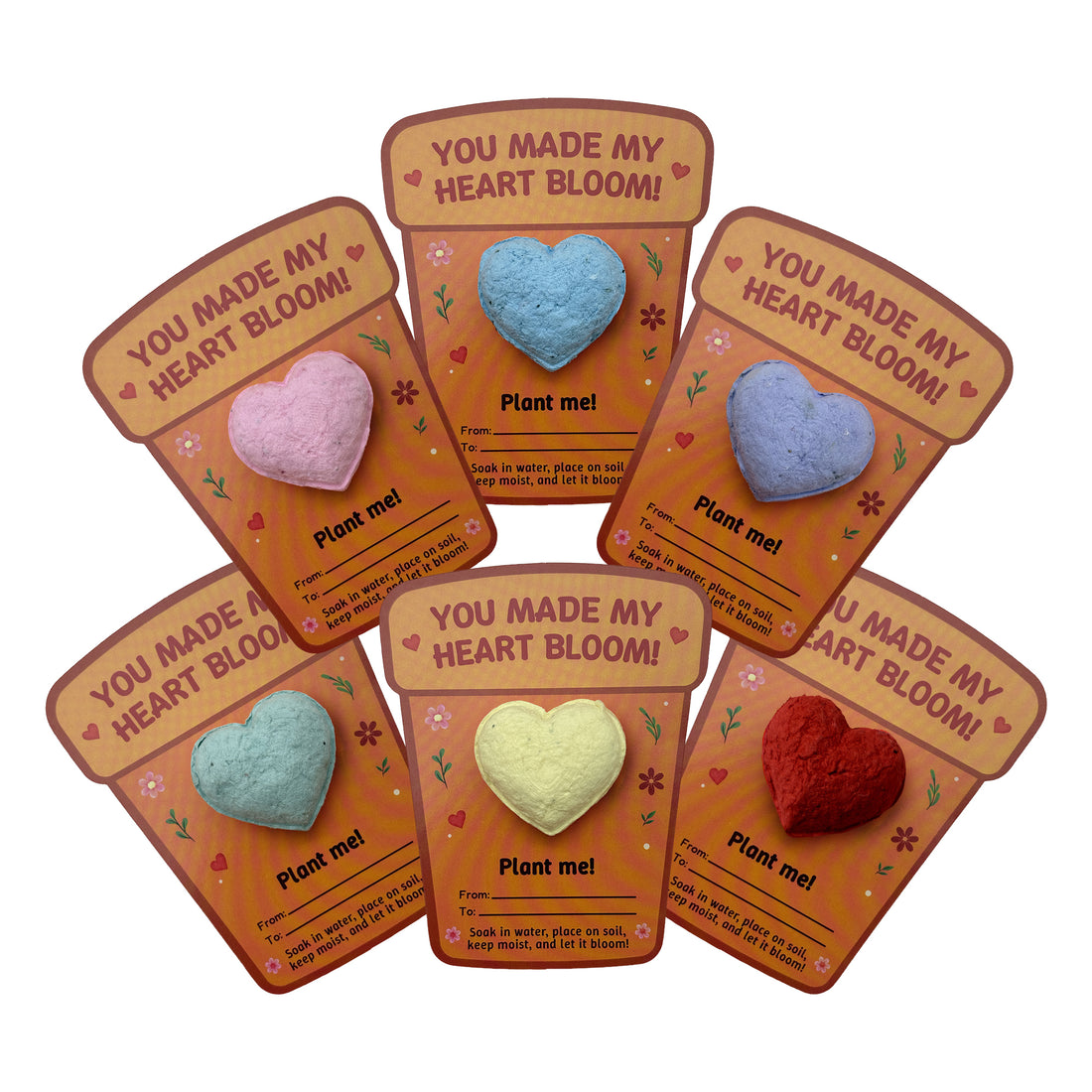 Assorted multicolor plantable 3D heart seed paper gifts displayed on illustrated “You Made My Heart Bloom” cards by Seed Bloom Gifts
