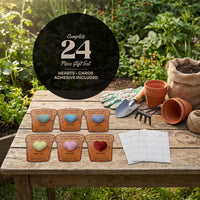 Seed Bloom 24-piece plantable heart seed paper gift set displayed on a wooden table with gardening tools, pots, and adhesive dots