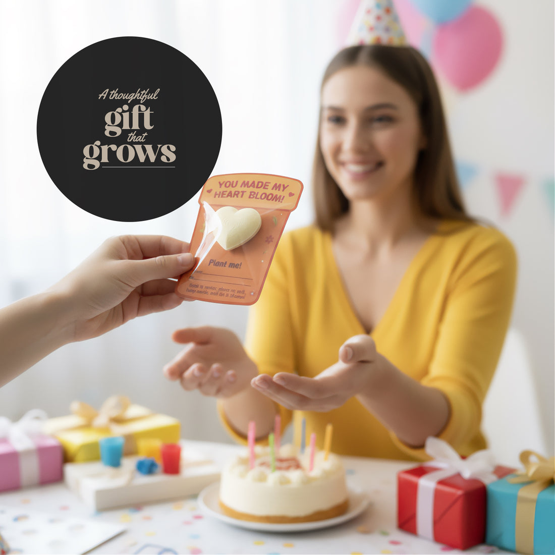 Person giving a 3d plantable heart seed paper gift to a woman at a birthday party with a cake and balloons.