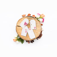Pink Blank Tags Plantable Seed Paper by Seed Bloom Gifts on a rough-cut wooden tree with flower petals