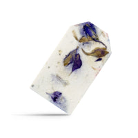 A single Purple Blank Tags Plantable Seed Paper by Seed Bloom Gifts with embedded purple and blue petals floats angled against a white background.