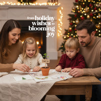 Family of four sitting around a table with a Christmas tree in the background, featuring text 'from holiday wishes to blooming joy' and looking down on a set of holiday plantable greeting card from Seed Bloom Gifts