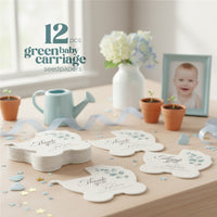 Set of baby carriage seed paper baby shower favor by Seed Bloom Gifts with floral designs on a wooden table with decorative items and picture frame of a baby
