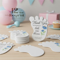 12 blue Baby footprint seed paper baby shower favor by Seed Bloom Gifts with floral designs on a wooden surface, with balloons and a cake in the background.