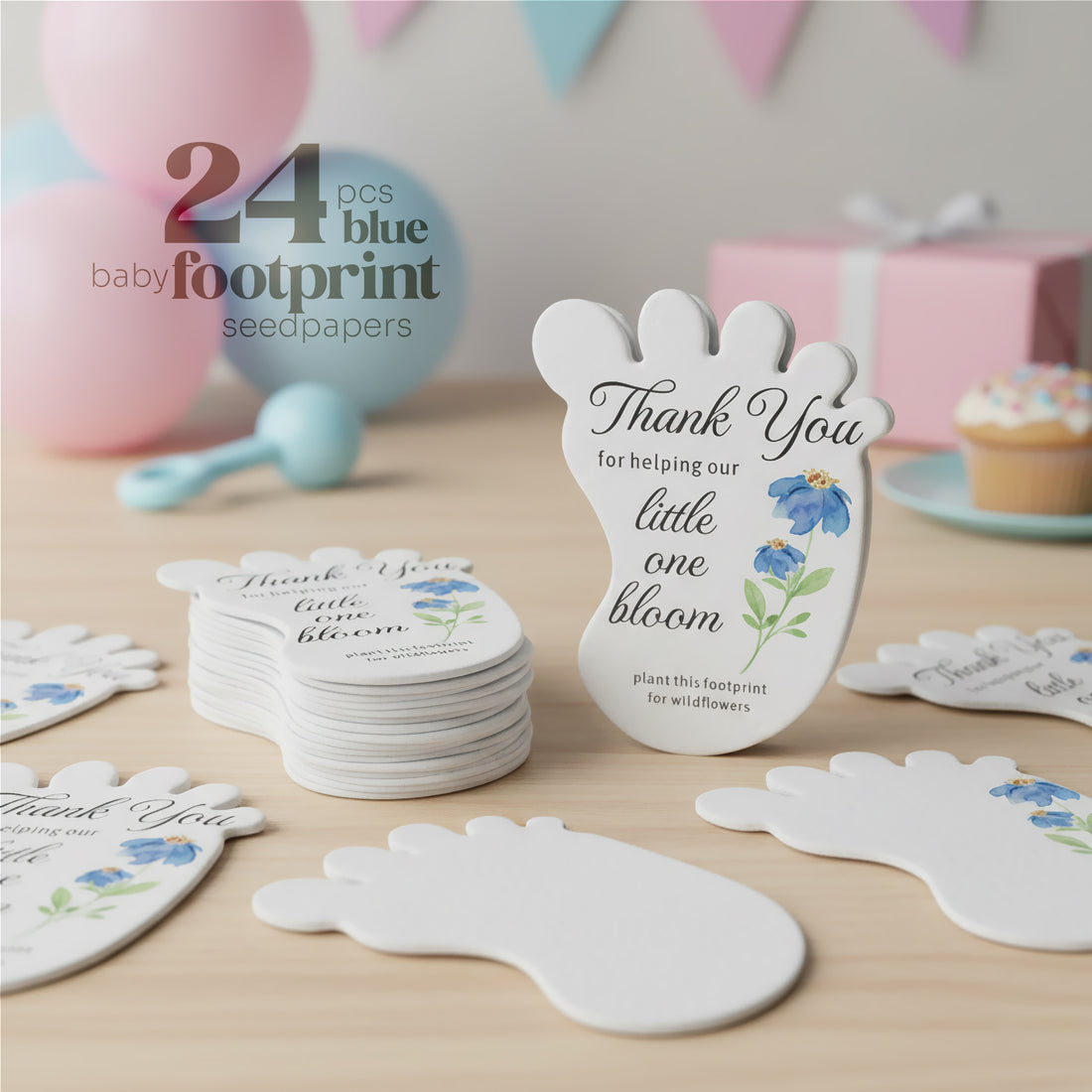 24 pcs Blue Baby footprint seed paper baby shower favor by Seed Bloom Gifts with floral designs on a wooden surface.