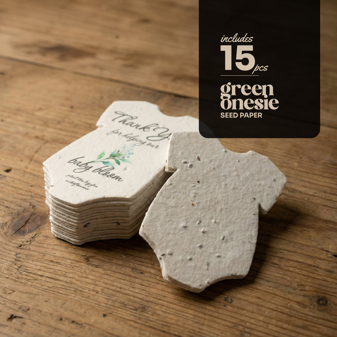 Seed paper baby onesie baby shower favor shapes by Seed Bloom gifts on a wooden surface with text overlay.