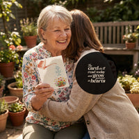 Smiling elderly woman with a Mother's Day Bloom card in her hand, showcasing her joy and appreciationSmiling elderly woman with a Mother's Day Bloom card in her hand, showcasing her joy and appreciation