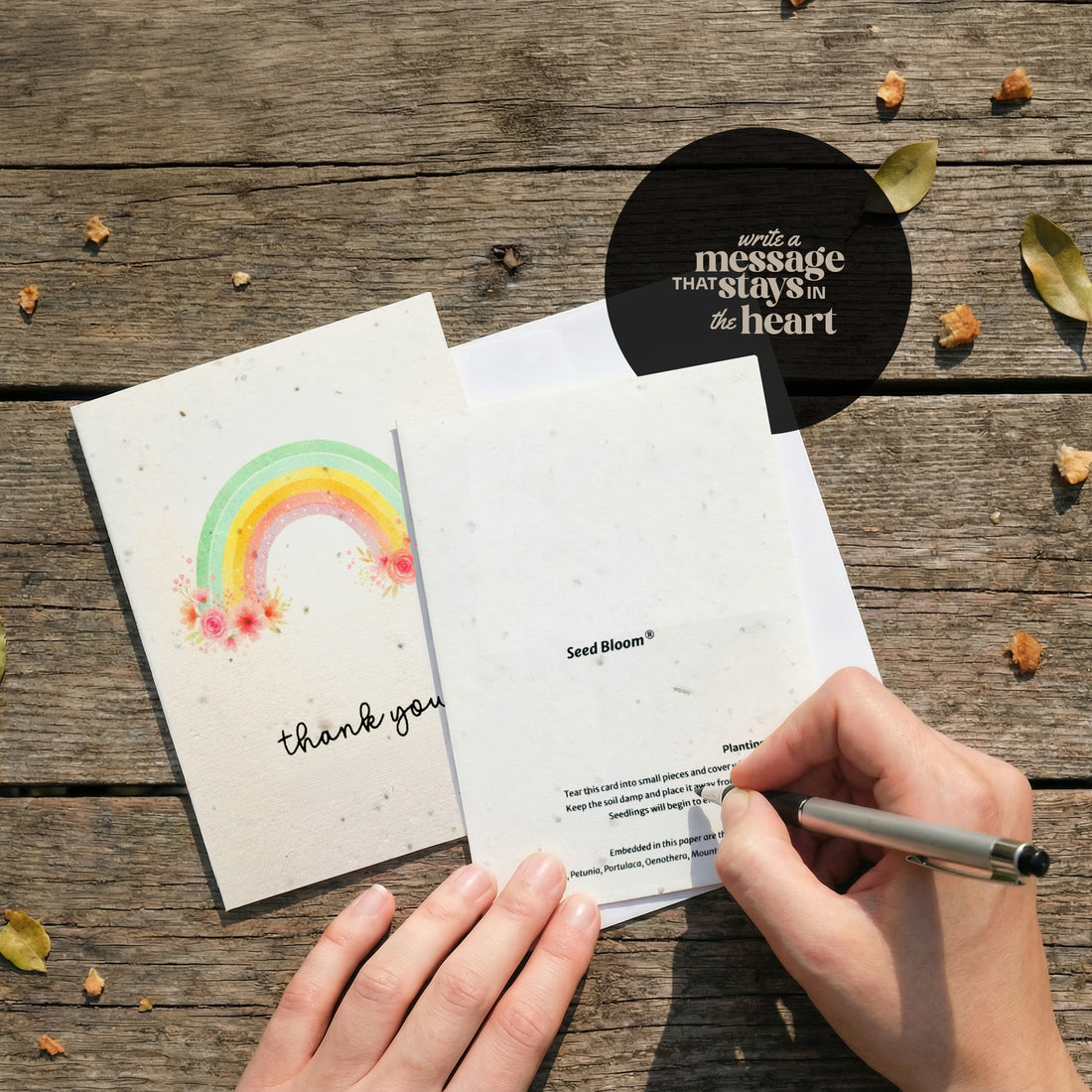 Seed paper thank you card opened showing front and back design with watercolor rainbow and wildflowers, featuring SeedBloom branding and planting instructions