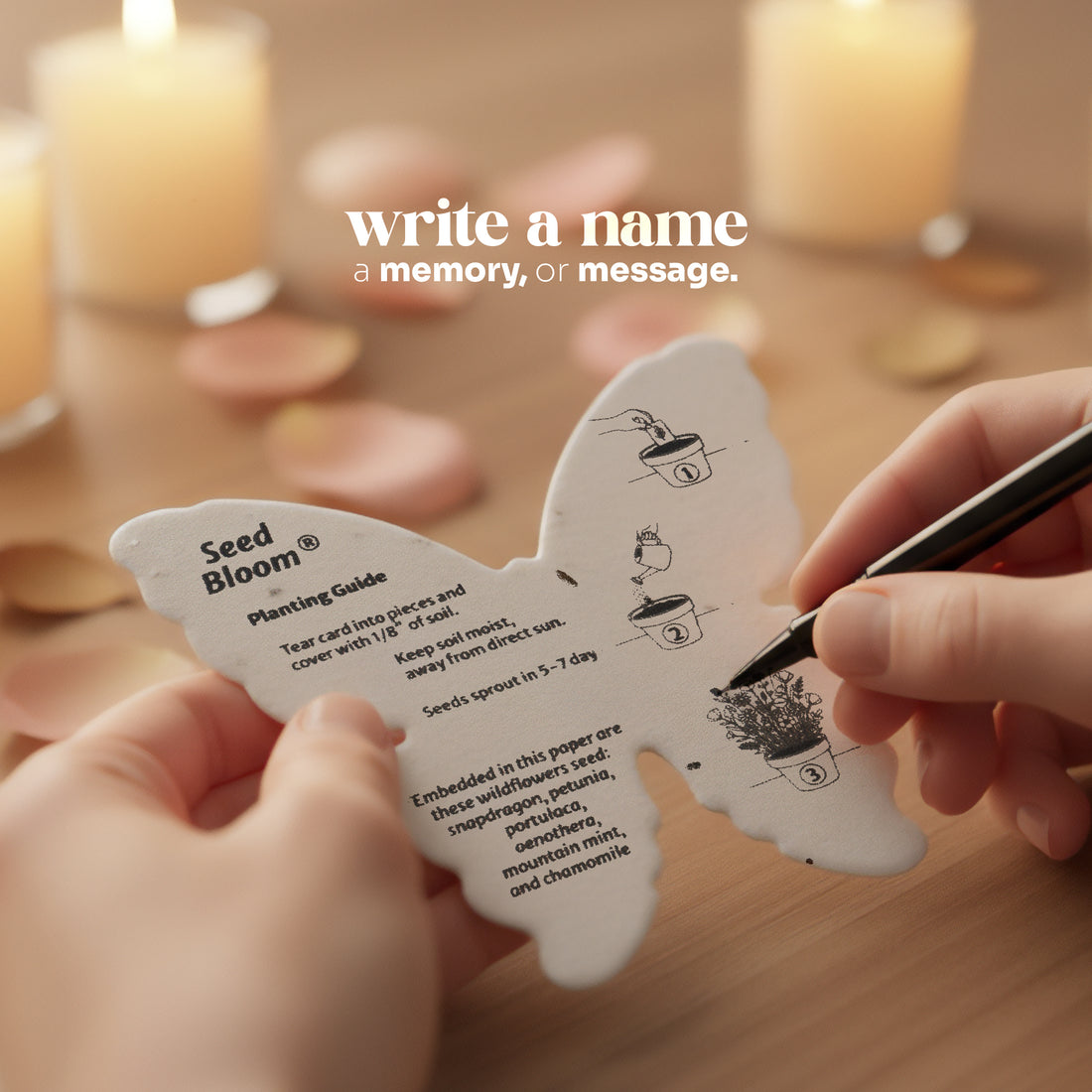 Butterfly-shaped seed planting guide with a hand holding a pen, set against a blurred candlelit background by Seed Bloom Gifts.