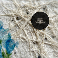 Close-up of a white and blue flower with a black center, featured on Bloom Thank You Tags