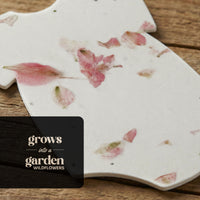 Bloom Plantable Seed Paper Baby Shower Kit onesie with pressed pink flowers that grows into a garden of wildflowers