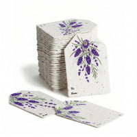 Floral Gift Tag Blooms - bulk set of seed paper gift tags with watercolor purple lavender botanical design, personalization fields for 'To' and 'From,' showing stacked inventory and individual tags with embedded wildflower seeds on cream cardstock