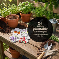 Plantable flower-shaped thank you tags 24-piece set with watercolor botanical designs displayed on wooden potting bench surrounded by terracotta pots