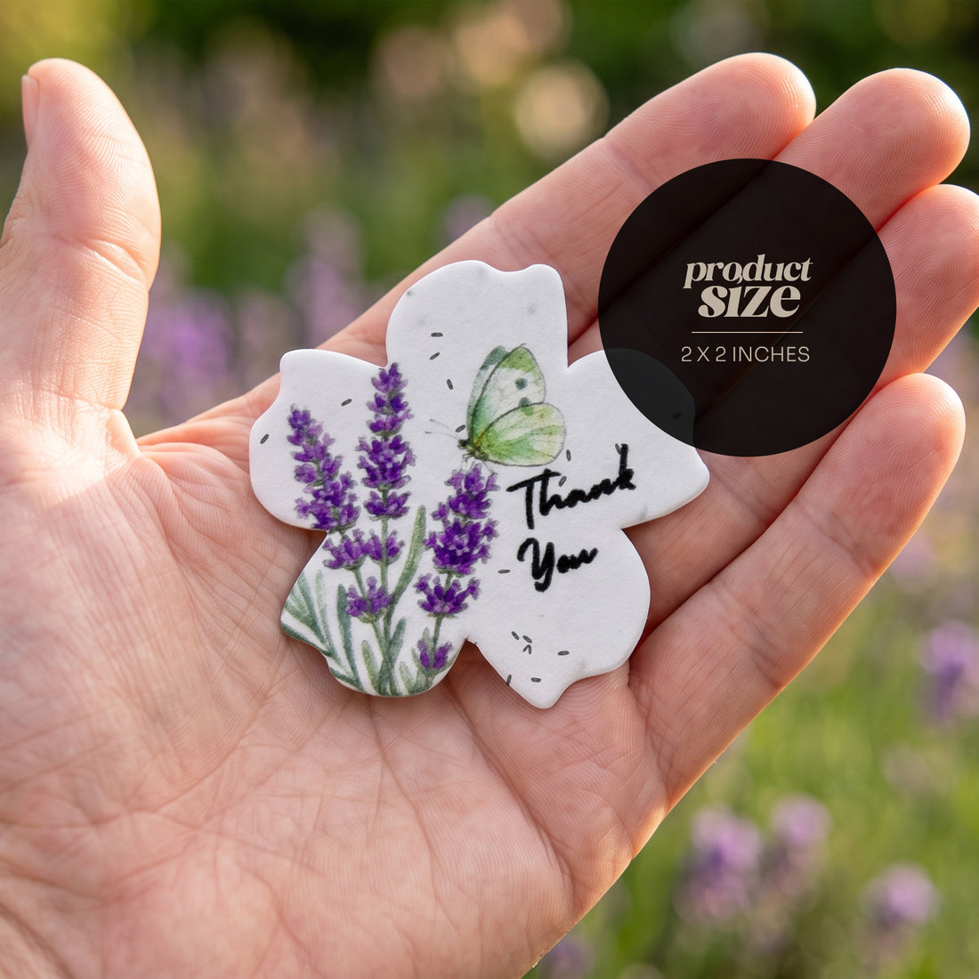 Scalloped flower-shaped thank you tag with watercolor purple lavender and butterfly design held in hand against garden background