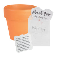 Terracotta pot with a pink onesie baby shower favor seed paper by Seed Bloom Gifts card and a small plant on a white background