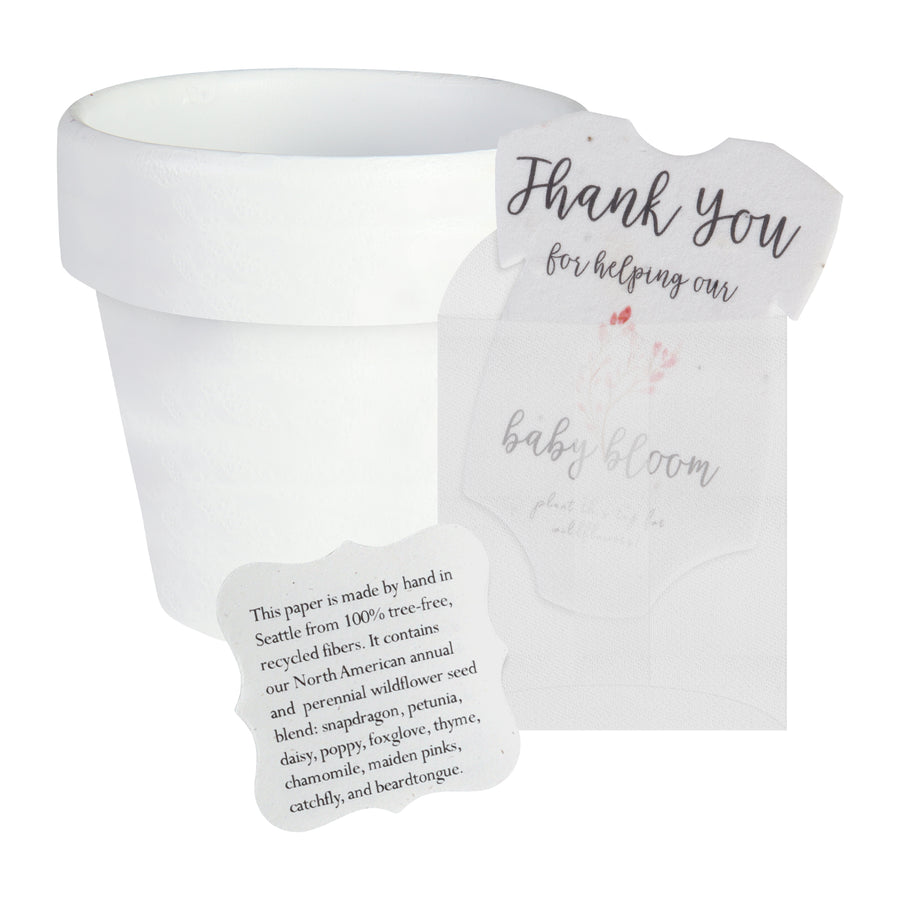 White paper pot with a pink onesie plantable seed paper baby shower favor by Seed Bloom Gifts on a white background
