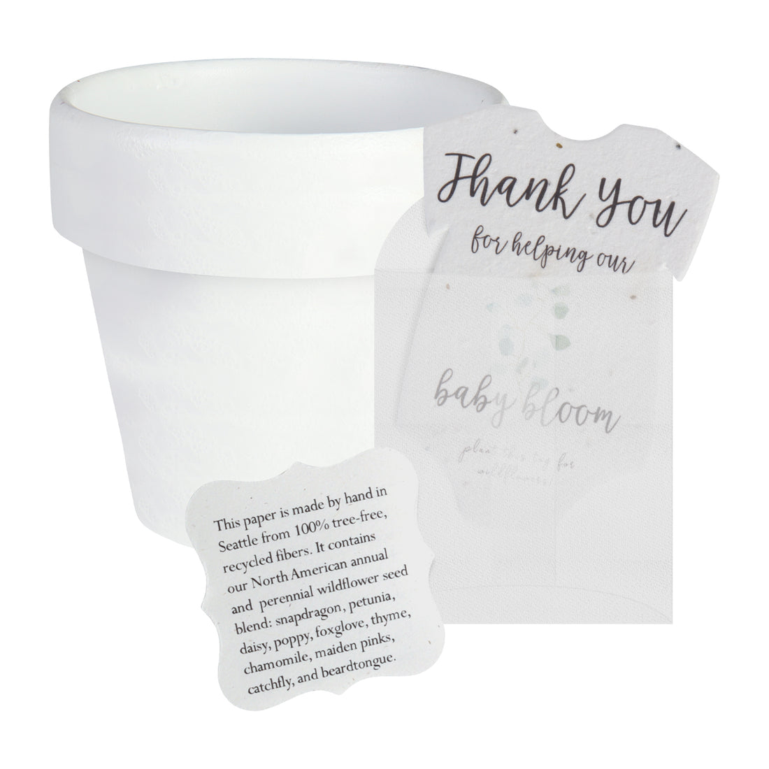 White pot next to a gender neutral green onesie plantable seed paper baby shower favor by Seed Bloom gifts, with a small card detailing the wildflower seed blend.