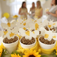Decorative 
Bee Shaped Seed Paper Baby Shower Favor By Seed Bloom Gifts with blurred people in the background