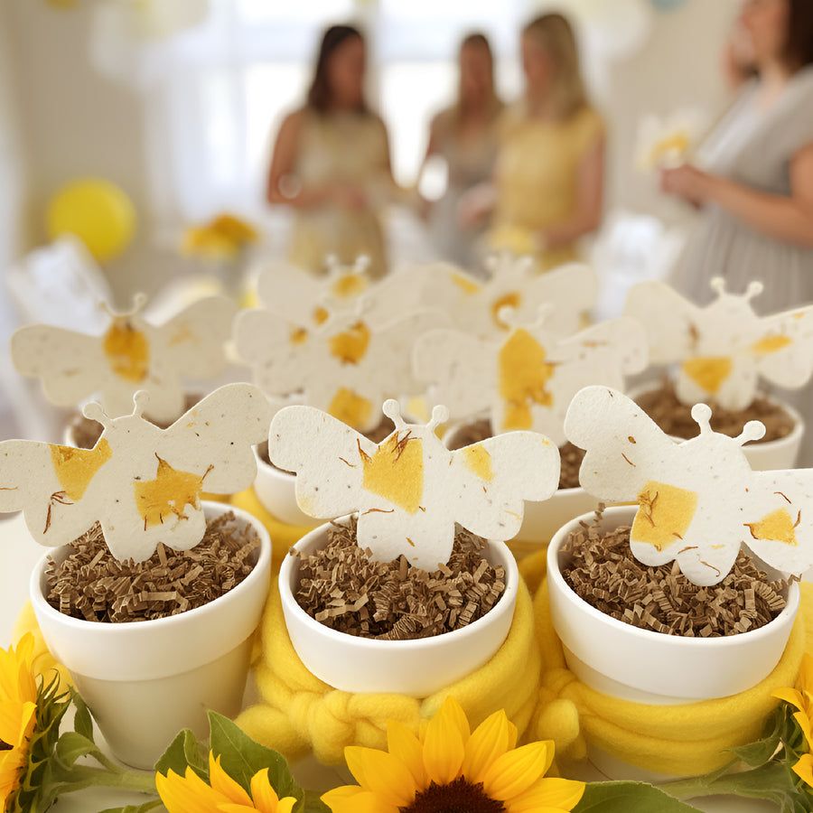 Decorative 
Bee Shaped Seed Paper Baby Shower Favor By Seed Bloom Gifts with blurred people in the background
