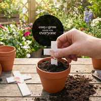 Bloom plantable seed paper cross funeral favor being planted in terra cotta pot with soil in garden, easy to grow for everyone