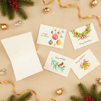 Plantable Holiday Christmas cards by Seed Bloom Gifts with festive designs on a beige background with decorations.