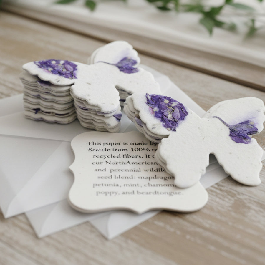 White paper butterflies with purple accents on a wooden surface