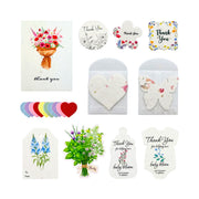 A set of floral thank you cards and small flower envelopes on a white background. The set includes a large greeting card with a bouquet illustration, several small thank you cards in different shapes, a stack of colorful round flower petals, and several white envelopes decorated with dried flowers and leaves.