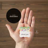 A hand presents a thank you card adorned with a small sticker that reads "Bloom Thank You Tags.